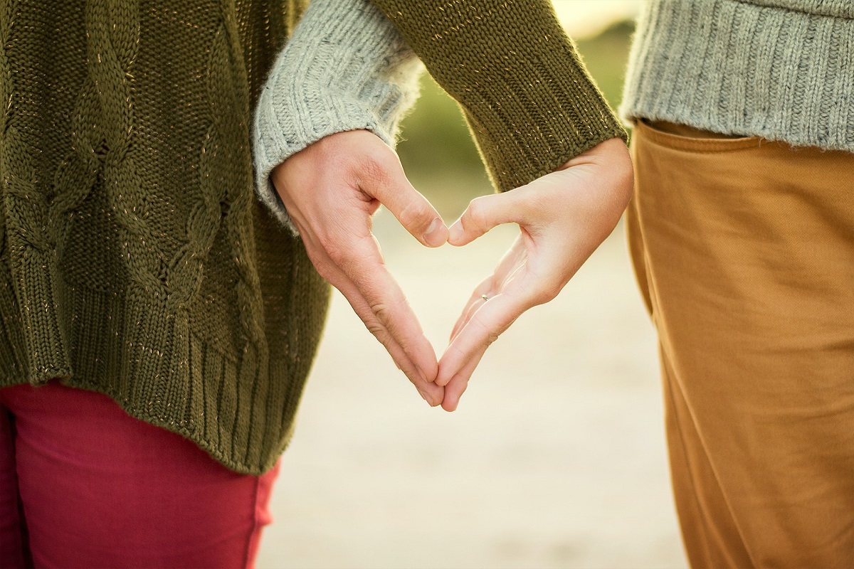 A couple making a heart shape with their hands