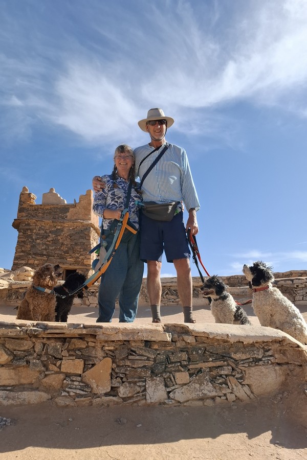 Jackie & Mark Lambert with The Fab Four cavapoos posing in front of the guard towe at Agadir Id Aissa, Amtoudi, Morocco