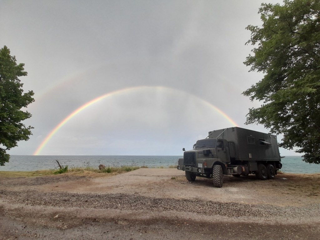 Volvo N10 truck, The Beast, parked on the shore of Lake Ohrid, Albania, with a rainbow behind