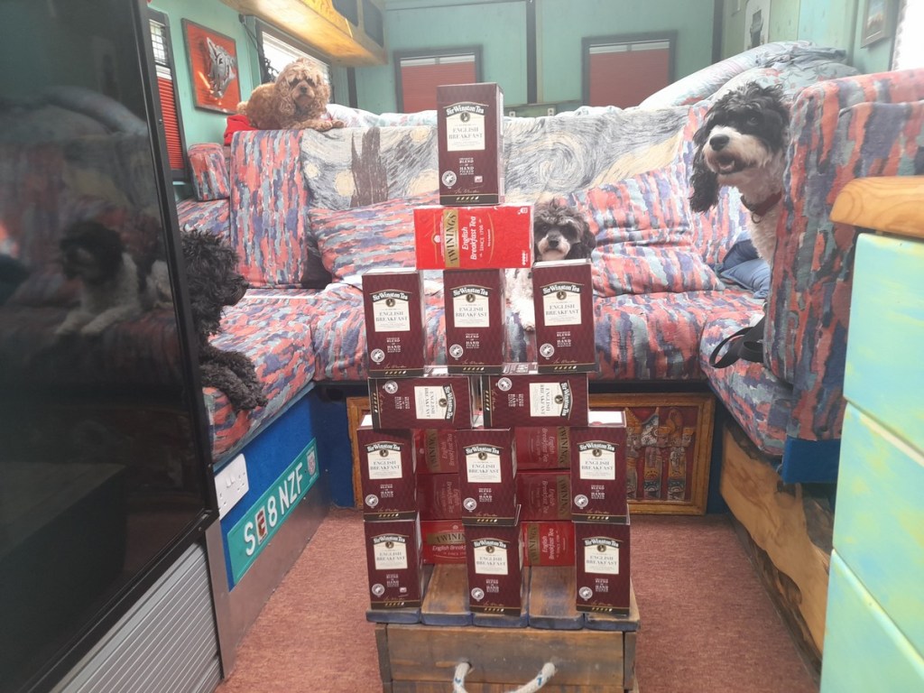 A stack of boxes of English Breakfast Tea with dogs looking on