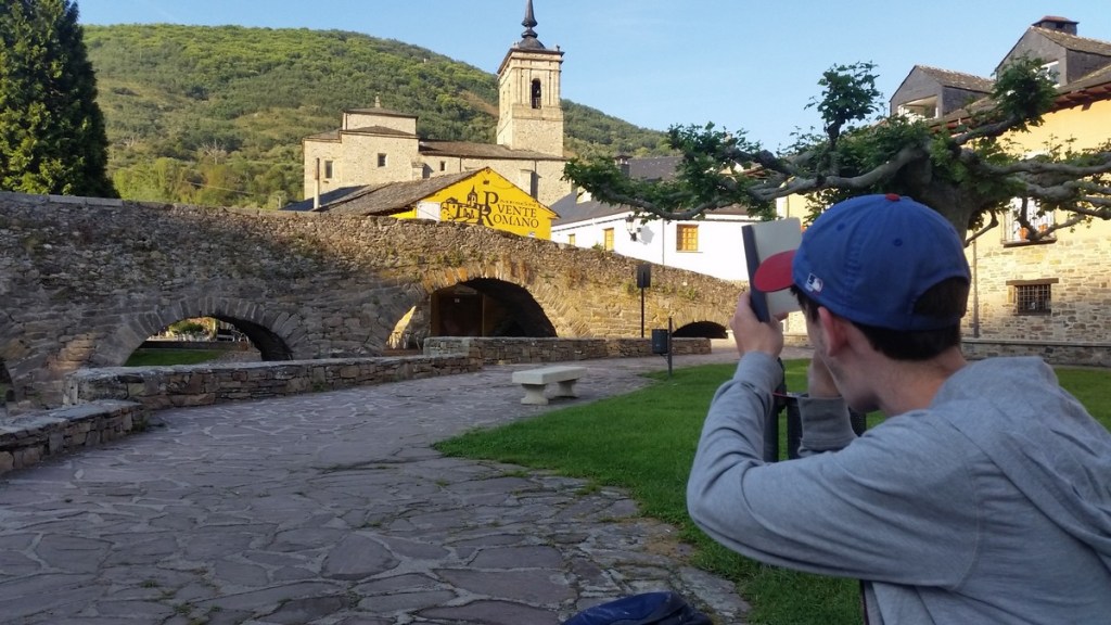 Author VM Karren's son squatting to take a photo on the Camino de Santiago