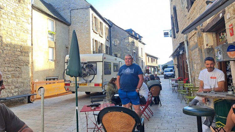 A caravan narrowly misses tables at the pavement cafe in Sévérac-le-Château
