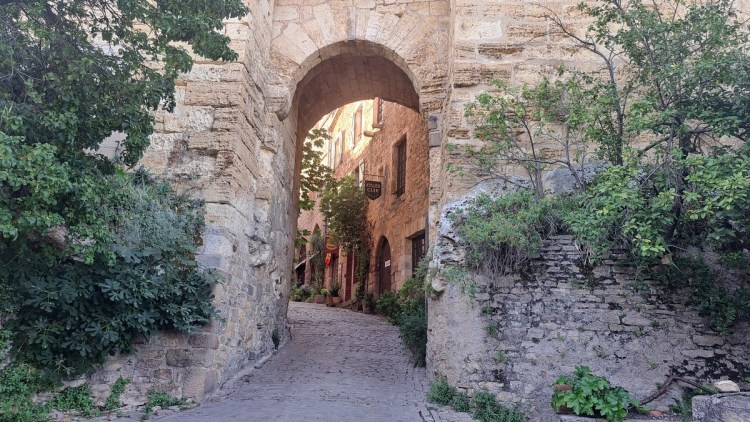 Gate through thick fortified walls in Cordes-sur-Ciel to illustrate its comception as a defensive structure
