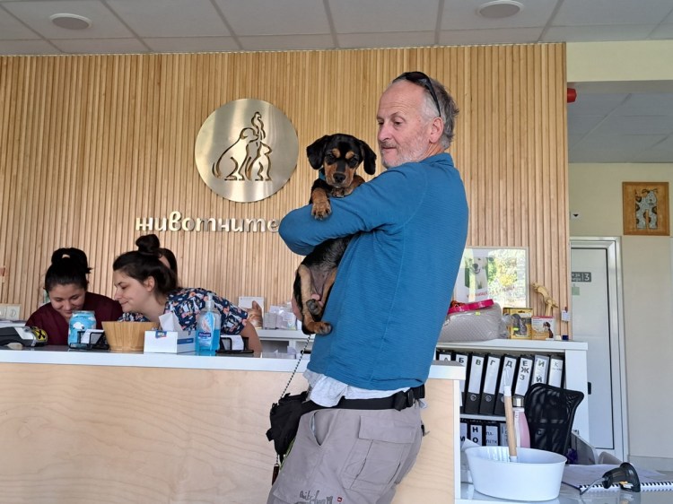 Black and tan dog in Mark's arms in Bulgarian vet