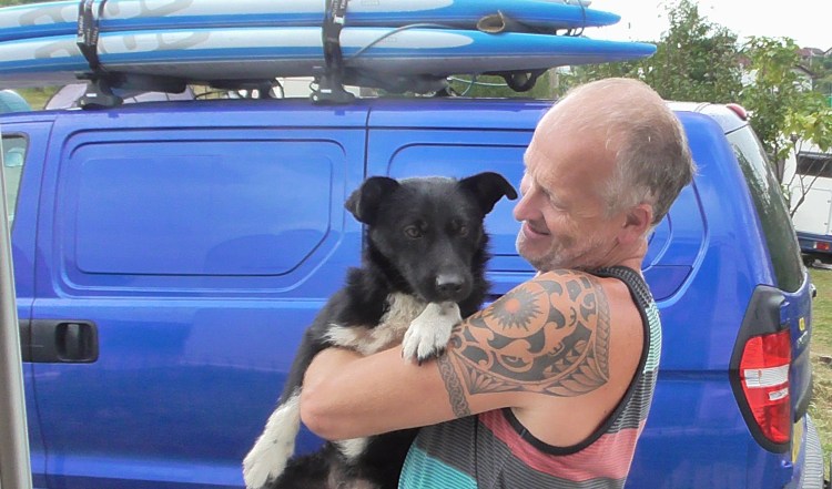 Mark holding a black dog in his arms - Blade the Transylvanian street dog we rescued