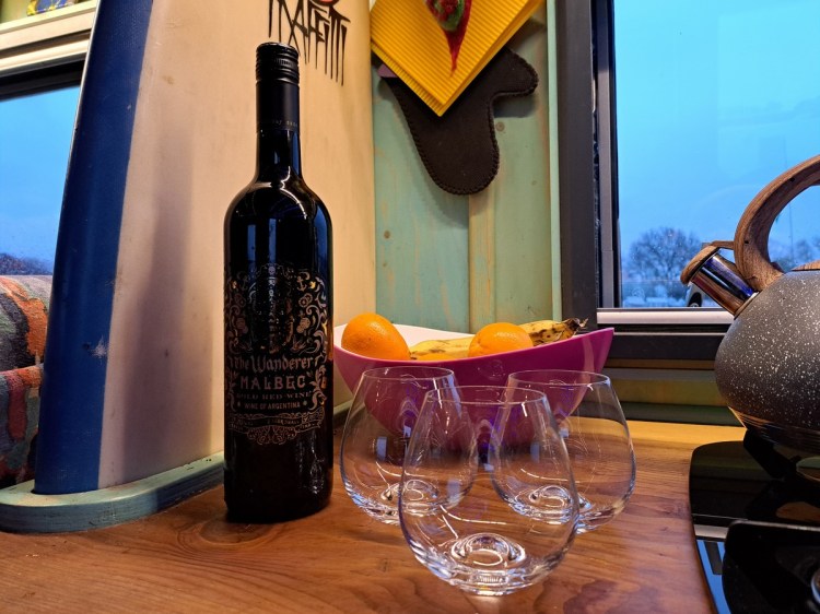 Bottle of The Wanderer wine and 3 glasses on the worktop of The Beast, Jacqueline Lambert's expedition truck. 
